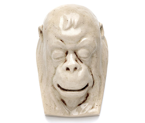 Skulptur eines Affenkopfs mit geschlossenen Augen