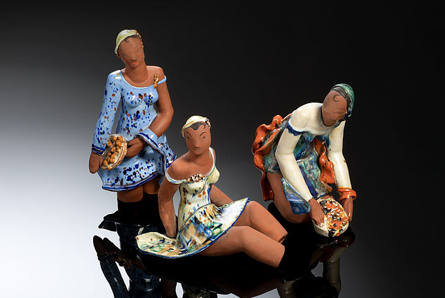 Drei Keramikfiguren die jeweils ein Mädchen darstellen.