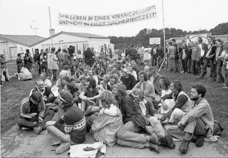 Sitzende Menschen unter einem Banner.