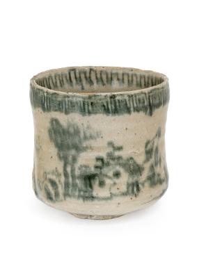 Kleiner, zylindrischer Keramikbecher aus der Sammlung des Badischen Landesmuseums mit leicht unregelmäßigem Rand und cremefarbener Oberfläche. Die grünlich verlaufende Glasur zeigt eine stilisierte Landschaft mit Bäumen und Gebäuden. Der obere Rand ist dunkler grün glasiert und wirkt tropfenartig strukturiert. Der Becher steht freigestellt vor hellem Hintergrund.