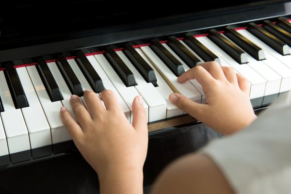 Kinderhände spielen auf den Tasten eines Klaviers. Das Motiv steht für einen Musikabend als Abendveranstaltung der Freunde des Badischen Landesmuseums und verbindet Musik mit Kultur und gemeinschaftlichem Museumserlebnis.