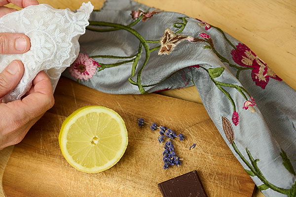 Hände ertasten bestickte Stoffe neben Zitrone, Lavendel und Schokolade bei einer Führung mit allen Sinnen.