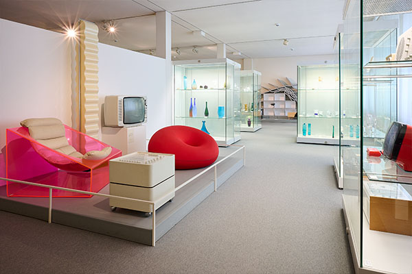 Ausstellungsraum im Badisches Landesmuseum mit Designobjekten, darunter ein transparenter Sessel, ein roter Sitzsack und ein alter Fernseher, Kultur und Alltagsdesign im Fokus.