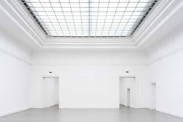 Leerer, weißer Ausstellungsraum mit großem Oberlicht und mehreren offenen Durchgängen in der Staatlichen Kunsthalle Baden-Baden. Die ruhige Architektur vermittelt eine stille Atmosphäre und verbindet Kunst, Raum und Kultur im Programm des Badischen Landesmuseums.