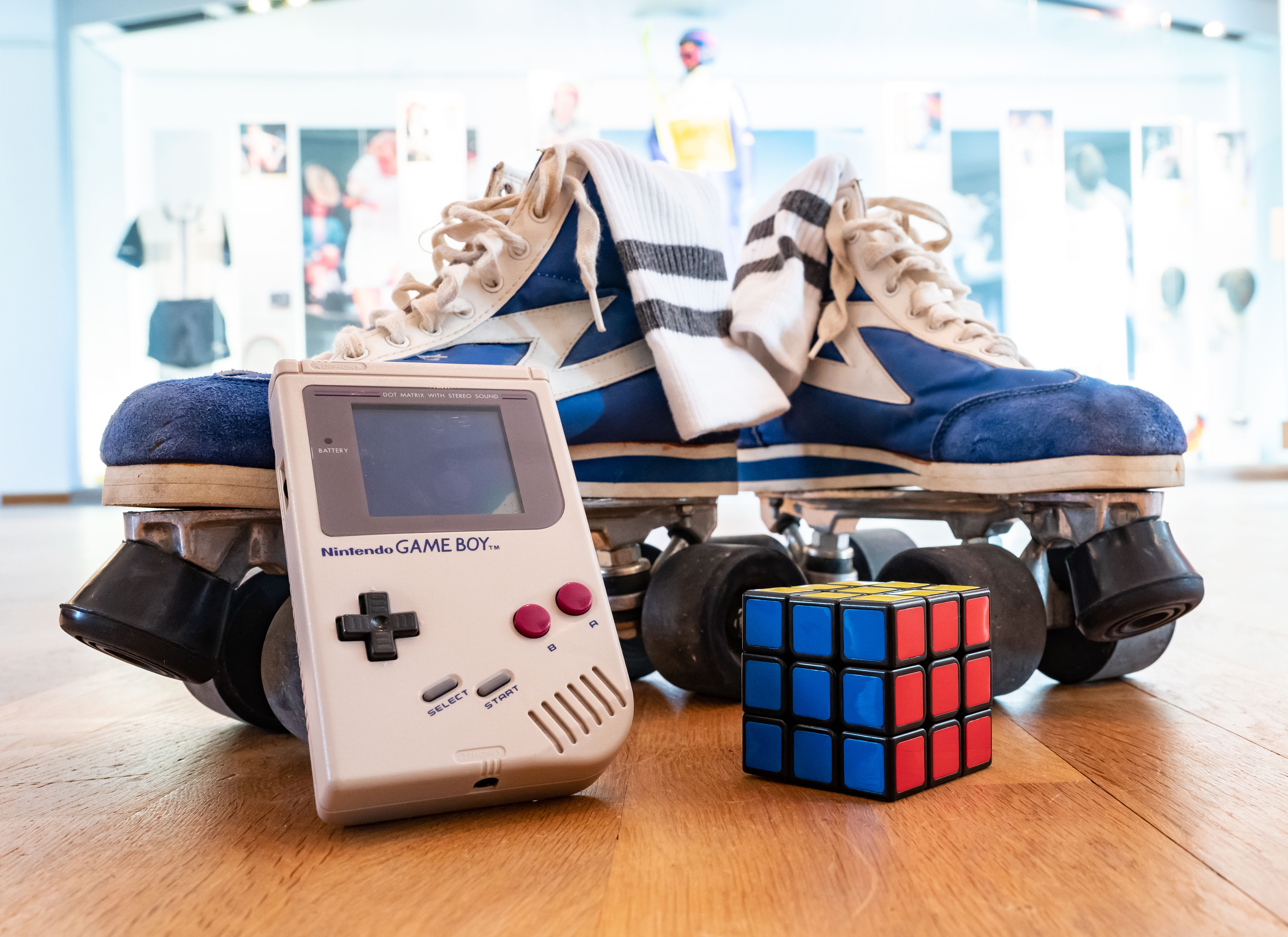 Gameboy, Zauberwürfel und Rollschuhe auf Holzboden