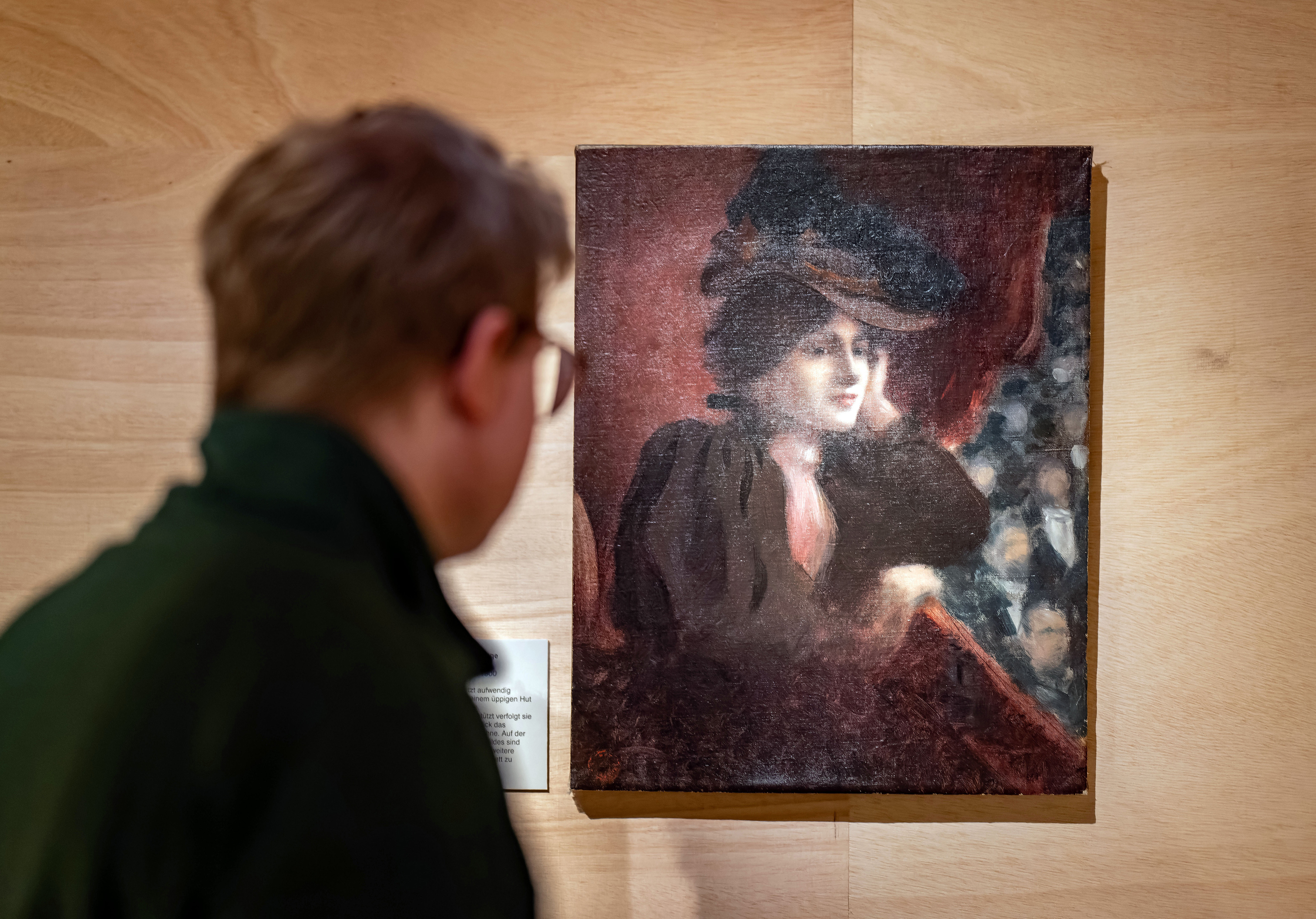 Besucher betrachtet ein Gemälde mit dem Porträt einer Frau