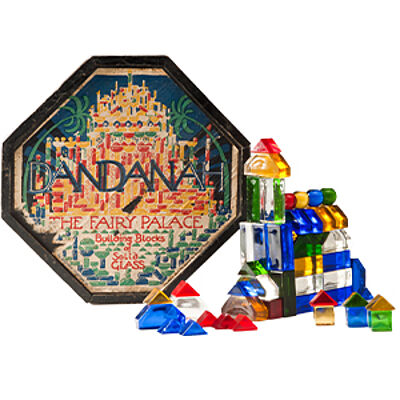 Bunte Glasbausteine und Schachtel des Spiels „Dandanah – The Fairy Palace“, ein historisches Konstruktionsspiel mit farbigen Elementen, aus der Sammlung des Badischen Landesmuseums und Kultur.