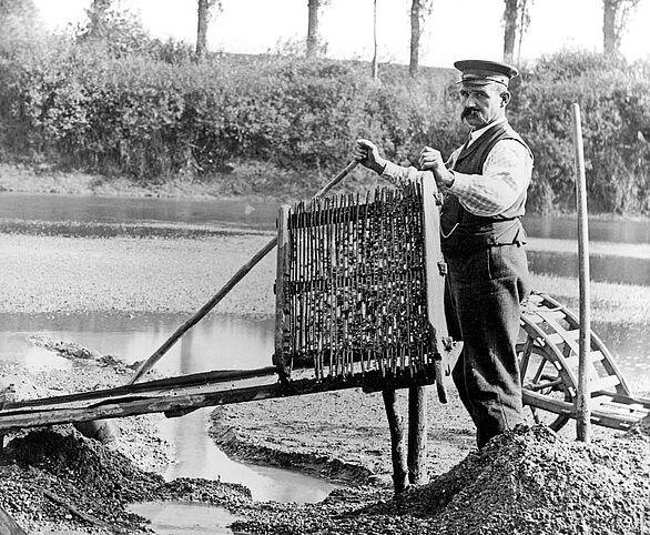 Ein Mann beim Goldwaschen am Fluss.