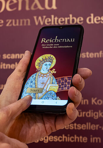 Smartphone mit der App "Reichenau - Der Guide zum Welterbe des Mittelalters"
