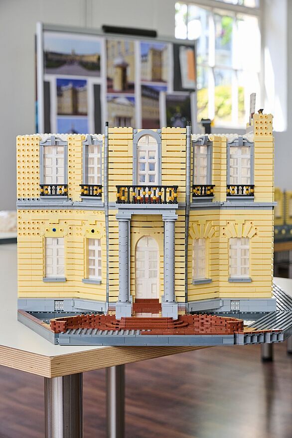 Frontansicht eines Pavillonteils des Karlsruher Schlosses aus Klemmbausteinen auf einem Tisch, Badisches Landesmuseum präsentiert Kultur als Architekturmodell