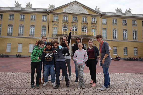 Kinder posieren in der Gruppe vor dem Schloss.