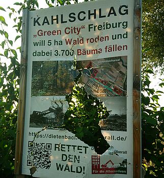 Ein beschädigtes Protestplakat, dass die Waldrodung für den Bau vonDietenbach kritisiert.