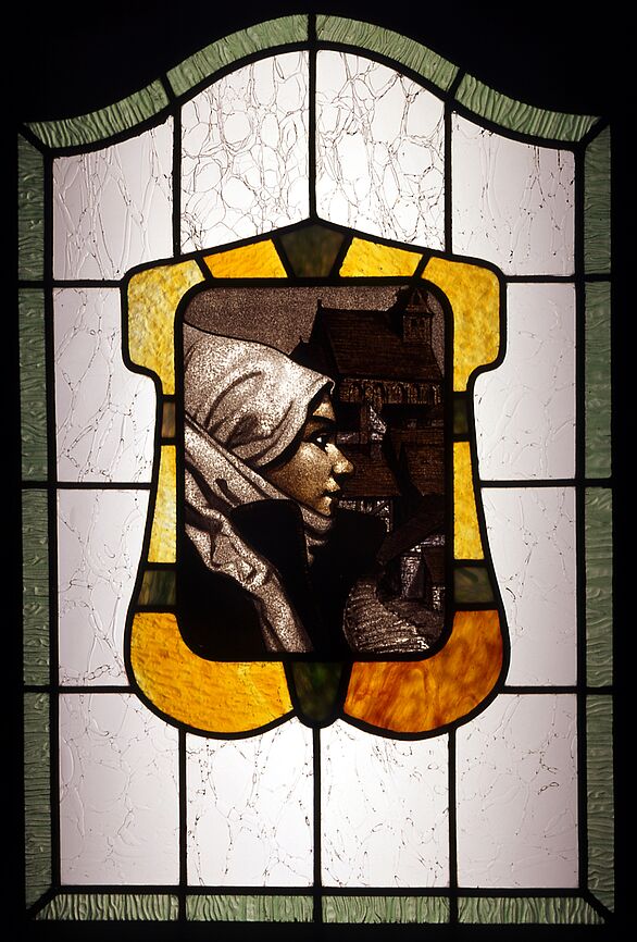 Buntglasfenster, das einen Frauenkopf im Profil zeigt.