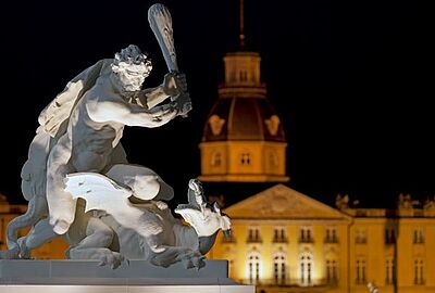 Nächtliche Ansicht vor dem Karlsruher Schloss mit der beleuchteten Herkules-Skulptur im Vordergrund. Das Motiv begleitet die September-Events des Badischen Landesmuseums und verbindet Kultur, Geschichte und Veranstaltungen in Karlsruhe.