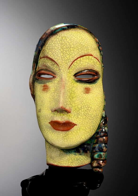 Keramikmaske eines Frauengesichts.