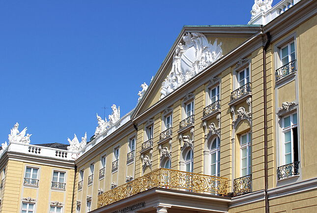 Exterior view of the Badisches Landesmuseum in Karlsruhe Palace against a blue sky.