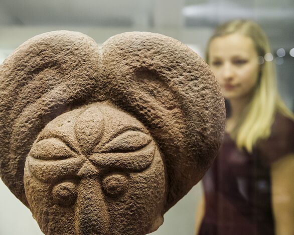 Eine Besucherin bestaunt die Skulptur des Heidelberger Kopfs