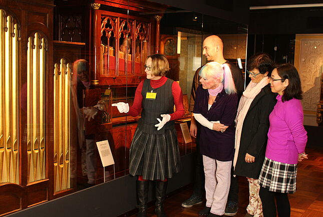 Besuchergruppe vor der „Church Barrel Organ“, London 1827