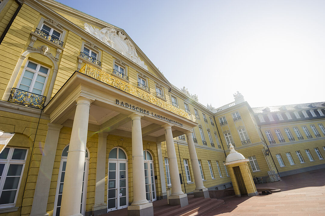 Exterior view of the Badisches Landesmuseum in Karlsruhe Palace against a blue sky.