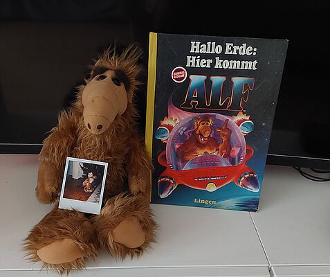 Puppe und Buch zur Fernsehserie "Alf"