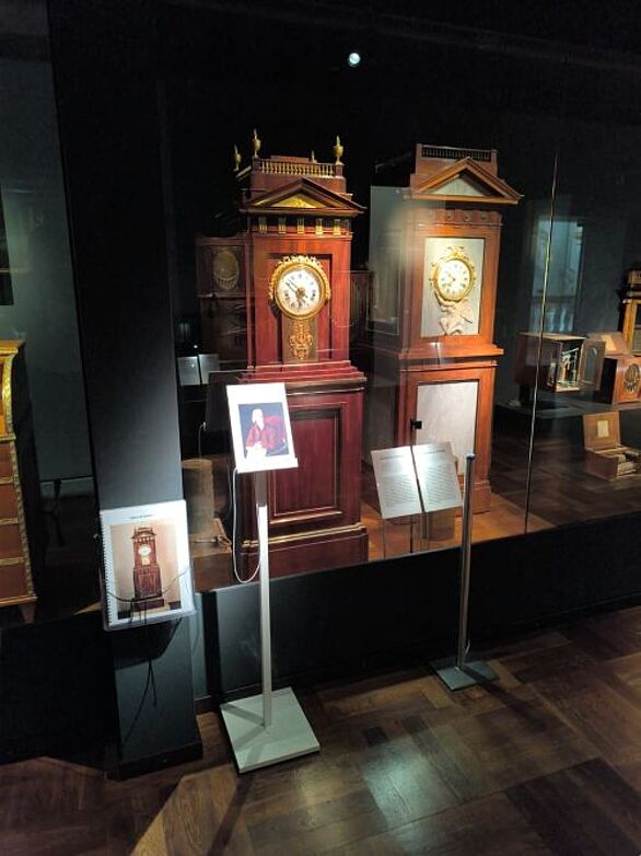 Blick in die Präsentation des Deutschen Musikautomaten-Museums mit zwei historischen Musikautomaten in hohen Holzgehäusen. Die Ausstellung „Zuhause – Unterwegs“ des Badischen Landesmuseums verbindet die Kultur mechanischer Musik mit ihrer internationalen Geschichte.