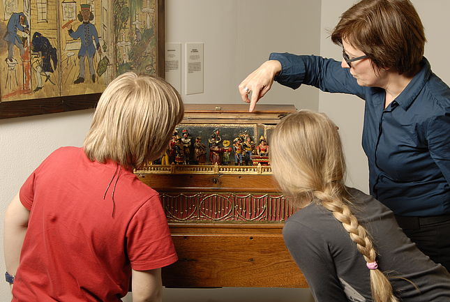 Vermittlerin mit Kindern an einer Orgel