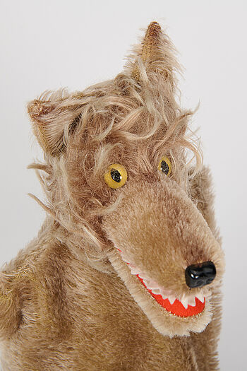 Eine braune Wolfshandpuppe mit gelben Augen