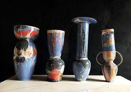 Vier nebeneinandergereihte Vasen.
